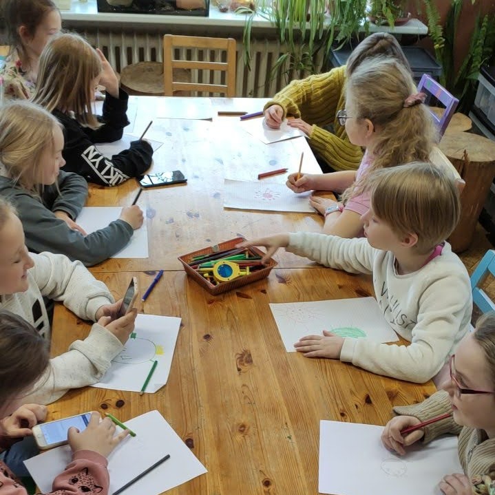 joonistavad lapsed istuvad laua taga 