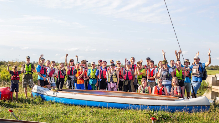Kamp noori seisavad rõõmsalt kanuude taustal