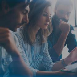 kaks meest ja naine nende keskel arutlevad keskkonnateemadel vaadates paberit enda ees